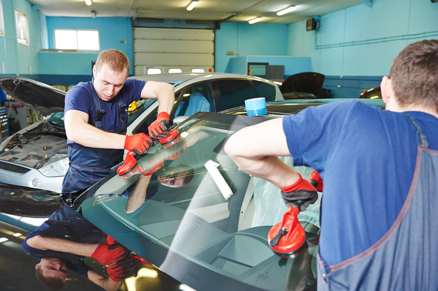 men installing a car windshield